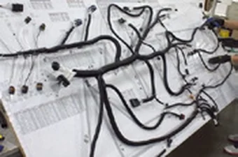 Cablaggio in lavorazione sul banco di montaggio, con i disegni di riferimento